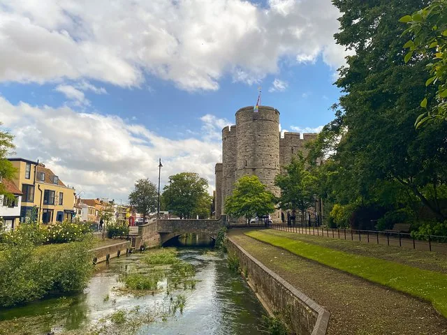 Scenic view of a medieval stone castle tower beside a canal.