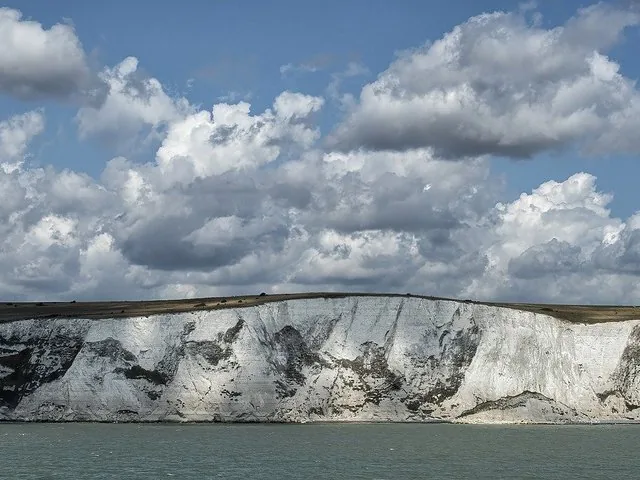 White Cliffs of Dover rising dramatically from the sea under cloudy skies