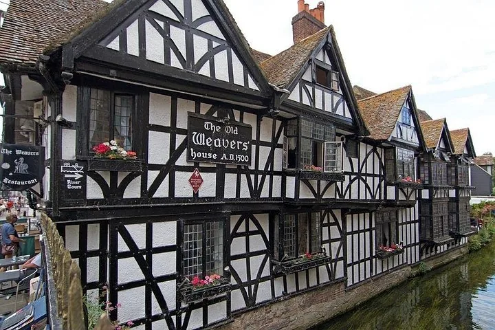 The Old Weavers' House, a historic half-timbered building over a canal.