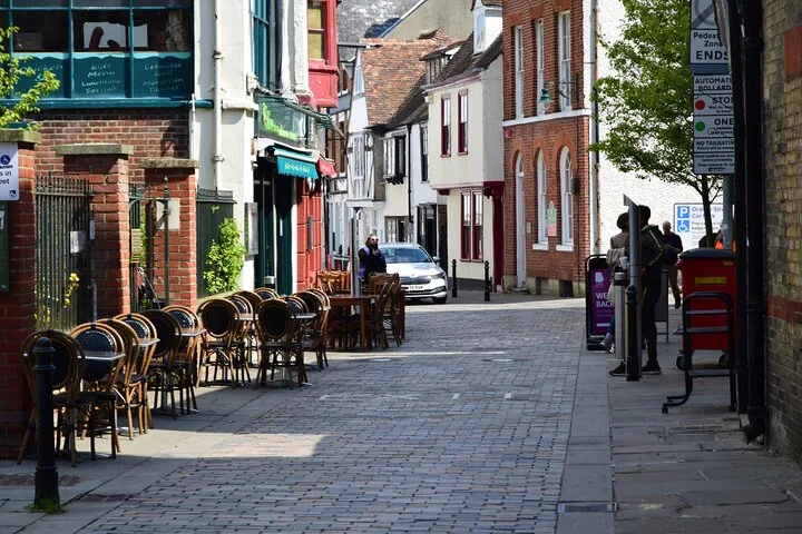 Cobblestone street with outdoor cafe seating and historic half-timbered buildings