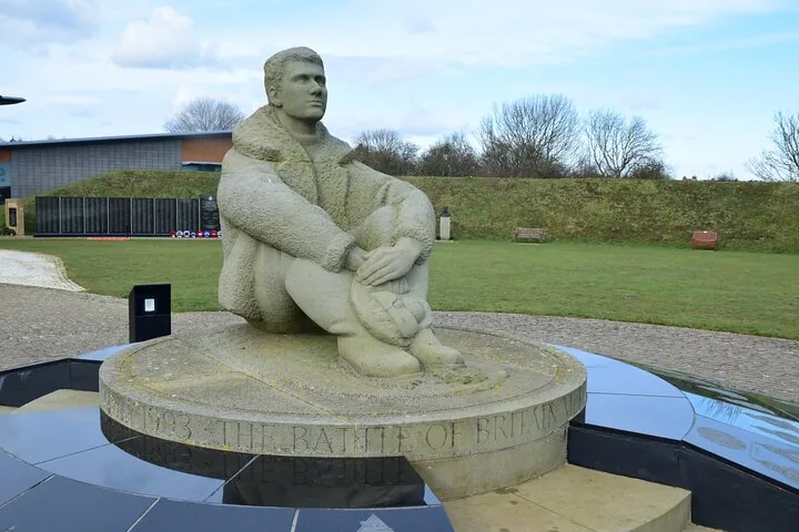 Stone statue of a seated pilot at The Battle of Britain Memorial